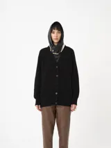 Cardigan negro de punto grueso, con botones y corte holgado, ideal para un look relajado.