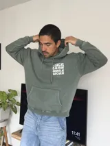 Canguro verde oliva con capucha y estampado en la espalda con la frase "Talk Less Smile More".