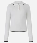Blusa blanca de punto con cuello polo y mangas largas. Presenta detalles contrastantes en negro en el cuello, la abertura frontal y el dobladillo.