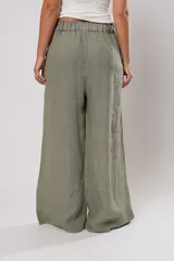 Pantalón verde oliva de lino, corte palazzo, con cintura elástica y aberturas laterales con botones.