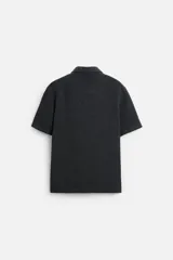 Camisa celeste de corte recto, manga corta y cuello solapa.