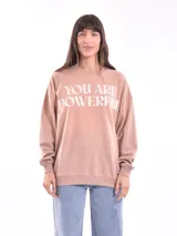Buzo color beige con estampa frontal con la frase "You are powerful" en letras blancas.