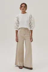 Jean de pierna ancha color beige, tiro alto y corte holgado.