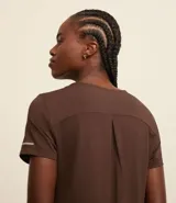 Remera deportiva blanca texturizada, con cuello redondo, manga corta, detalle reflectante y pliegue en la espalda.