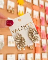 Par de aros colgantes de fiesta con forma de hoja o ramillete, compuestos por múltiples cristales facetados de color champagne o dorado claro, engarzados en una base metálica dorada.