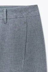 Pantalón de vestir celeste con corte palazzo, tiro alto, bolsillos laterales y cierre frontal con cremallera y botón.