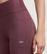 Bermuda deportiva femenina de microfibra color ciruela, corte ajustado y largo tipo ciclista, con bolsillos laterales. Confeccionada con poliamida y elastano.