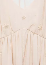Vestido largo color rosa pálido con tirantes finos y escote en V. Tiene detalle de abalorios y cierre de lazo en la espalda.