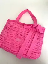 Bolso tipo tote color fucsia, 100% algodón, con diseño drapeado, moña fija y grifa de acrílico Cilento.