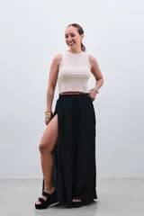 Pantalón palazzo negro con cintura elástica y aberturas laterales altas.