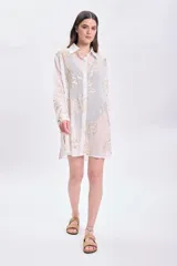 Camisa blanca de algodón con estampado de ramas doradas, de corte recto y mangas largas.