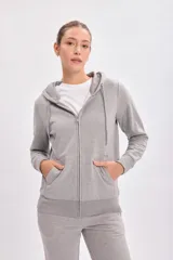Campera deportiva gris claro con capucha, cierre frontal y bolsillos laterales.