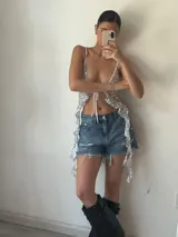 Short de jean azul claro con roturas y detalles de encaje con lentejuelas en los laterales.