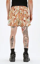 Short de baño con estampado abstracto en tonos verde, naranja y celeste. Tiene cintura elástica con cordón ajustable.