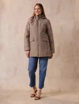 Campera capitoneada color beige, marca Weatherproof, con capucha desmontable, cierre central, bolsillos delanteros con cierre, tajo lateral con botones y forro interno a tono.