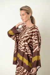 Blusa italiana con estampado de cebra en tonos beige y azul marino, con guarda marrón en el bajo. De calce holgado y mangas tres cuartos.