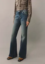 Pantalón de jean acampanado de tiro alto, color azul denim, con cinco bolsillos y trabillas.