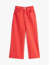 Pantalón jean de pierna ancha color rojo, de talle alto y corte tobillero.