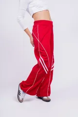 Pantalón deportivo rojo con detalles de líneas blancas curvas en los laterales.