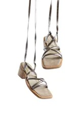 Sandalias plateadas con tiras finas cruzadas y tobilleras con cordones. Tacón de madera.