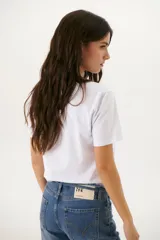 Remera blanca con estampado de moldes de costura en color marrón.