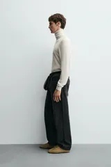 Jersey negro de punto fino con cuello alto y manga larga.