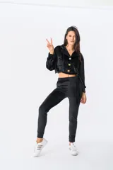 Campera corta de terciopelo negro con cuello camisero, cierre frontal con botones dorados, mangas largas con puños elásticos, dos bolsillos de parche en el pecho y lazo para atar en la cintura.