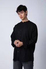 Camisa negra de lino con cuello mao, manga larga y corte clásico. Cierre frontal con botones.