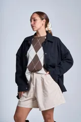 Sobrecamisa color beige de gabardina con cuello camisero, cierre frontal con botones a presión, dos bolsillos de parche en el pecho y corte holgado.