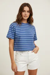 Remera cropped azul con rayas horizontales blancas, de poliéster, holgada y con cuello a la base.