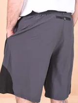 Short deportivo gris oscuro con cintura elástica ajustable con cordón, bolsillos laterales y logo estampado en la pierna derecha.