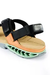 Sandalias Kenner Rakka Cross Craft, color negro y naranja, con suela de goma texturizada en verde agua.