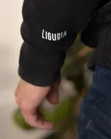 Hoodie negro de algodón grueso con capucha, cordones con detalles metálicos y bolsillo tipo canguro.