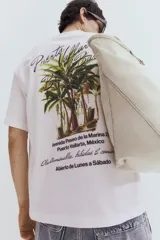 Remera blanca de algodón con cuello redondo y hombros caídos. Estampado pequeño en el pecho con la frase "Puerto Vallarta Beach Bar". Corte holgado.