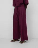 Pantalón de mujer de algodón orgánico color borgoña, con cierre de botón, cinturilla elástica en la espalda, doble pinza en el delantero, bolsillos laterales y pierna ancha.