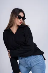 Buzo blanco de mangas largas con cuello polo y etiqueta de marca en el ruedo.