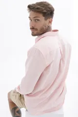 Camisa rosa de manga larga con cuello clásico y cierre frontal con botones. Corte recto.