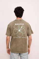 Remera verde militar de corte oversize con cuello redondo y estampado en la espalda con el logo de Brixton, una flor de hibisco y la frase "Where hibiscus grows, peace flows".