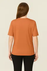 Remera color ladrillo con estampado de un elefante dibujado con una sola línea negra.