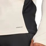 Camiseta de fútbol Adidas del Liverpool FC, modelo Tiro 25. Color crema con detalles en rojo y negro. Cuello alto con cierre de cremallera, mangas largas con puños con abertura para el pulgar, escudo del club termotransferido y tecnología Aeroready.