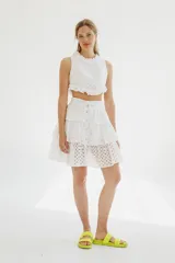 Top blanco de broderie con cuello halter y detalles de volados en el cuello y el ruedo.