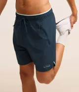 Bermuda deportiva azul marino de poliéster con elastano, con cintura elástica ajustable con cordón, bolsillos laterales con cierre y estampado localizado.