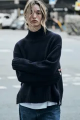 Sweater negro de punto con cuello alto y mangas largas.