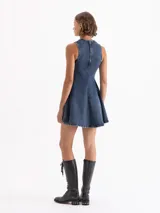 Vestido corto de denim azul con gran elasticidad, sin mangas y cuello redondo. La parte superior es ajustada y la falda tiene vuelo. Presenta un lavado irregular con efecto desgastado.