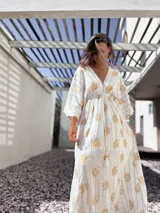 Túnica larga de algodón color blanco con estampado de flores y rayas verticales doradas, escote en V y mangas 3/4.