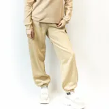 Pantalón de jogging color beige, con cintura elástica ajustable con cordón, bolsillos laterales y un bolsillo tipo cargo con solapa en la pierna derecha.