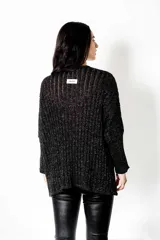 Poncho negro tejido en lurex, de calce suelto y relajado.