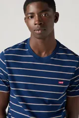 Remera de hombre azul con rayas horizontales blancas y logo rojo pequeño en el pecho.