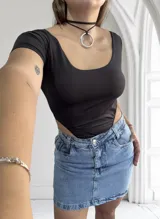 Body negro de mangas cortas con escote redondo y corte cavado en la parte inferior.