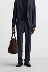 Pantalón de vestir azul marino, de corte recto, con pinzas frontales, bolsillos laterales y traseros de ojal. Se cierra con cremallera y doble botón.